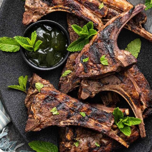 Grilled chops on serving plate with mint jelly.