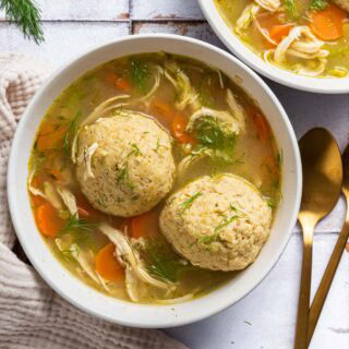 Bowl of cooked soup with two matzo balls