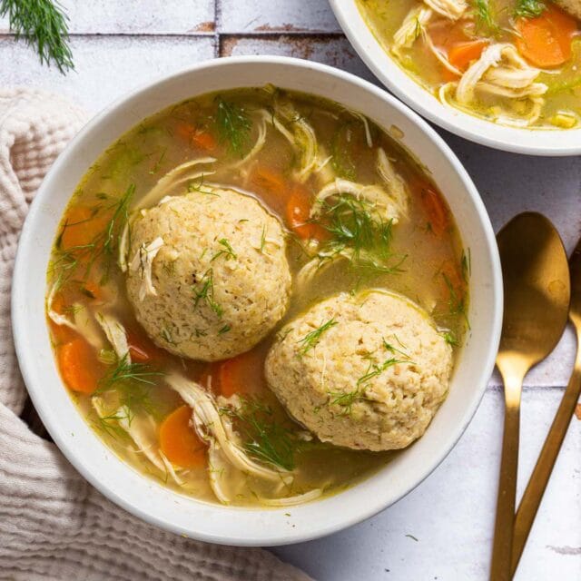 Bowl of cooked soup with two matzo balls