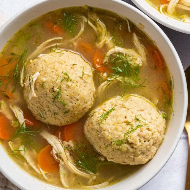 Portion of soup in bowl with 2 matzo balls