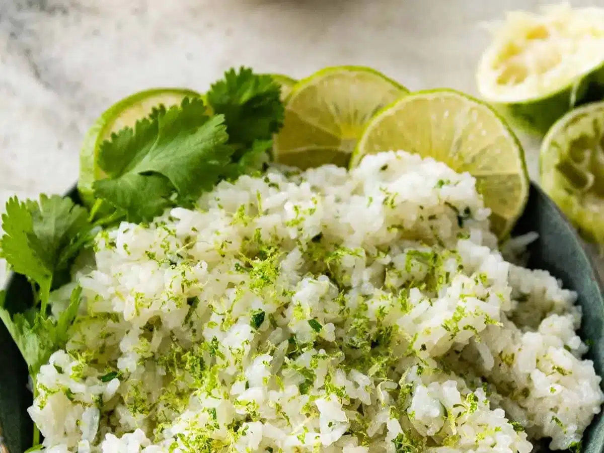 rice with cilantro in bowl with limes on side