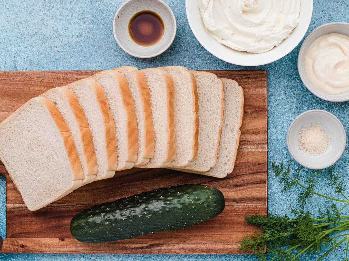 bread on cutting board with cucumber 
