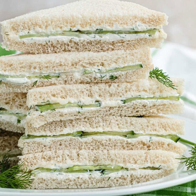 Stack of cucumber sandwich halves on plate