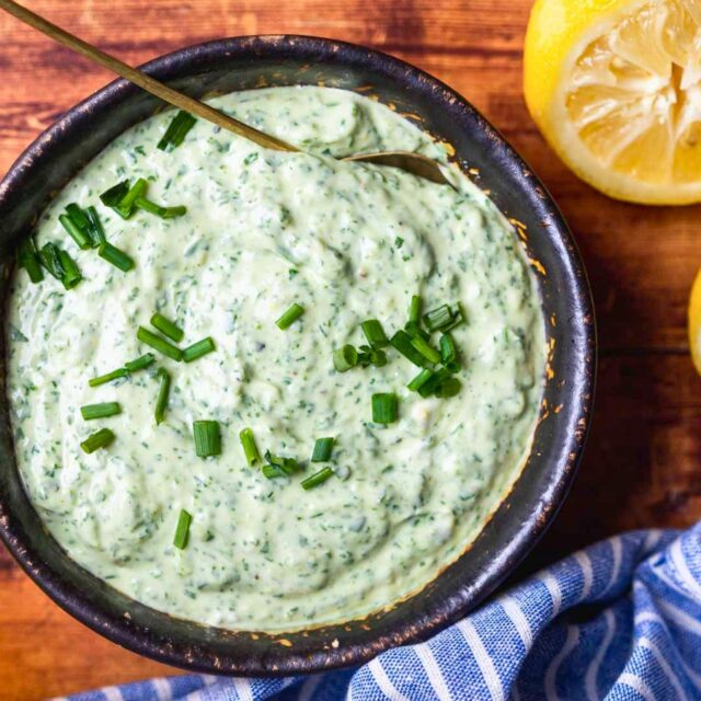 Green goddess dressing in small serving bowl with spoon.