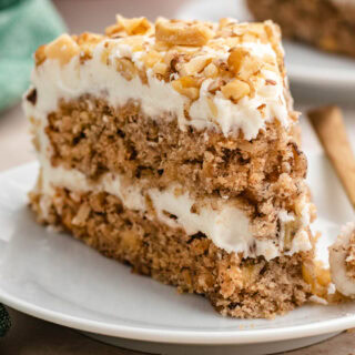 Slice of frosted cake on plate with bite on fork