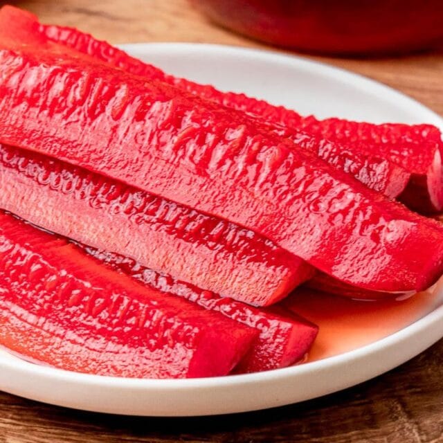 Red pickles piled on a serving plate.