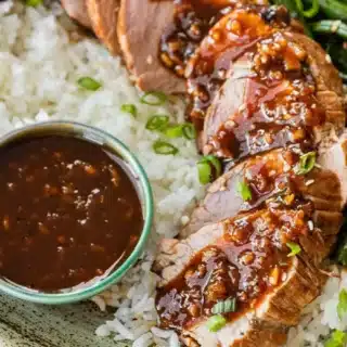 Pork served with rice and sauce on plate