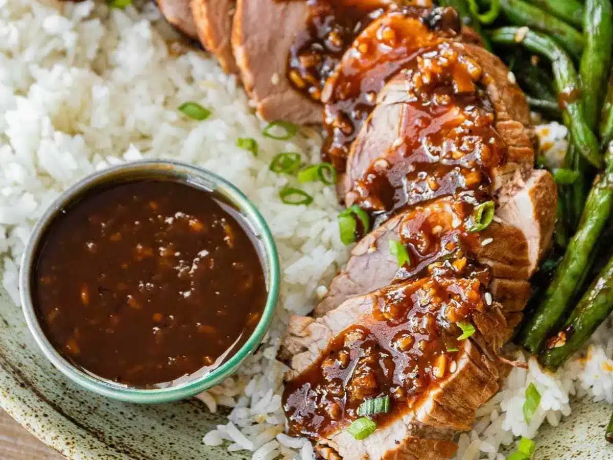 Pork served with rice and sauce on plate