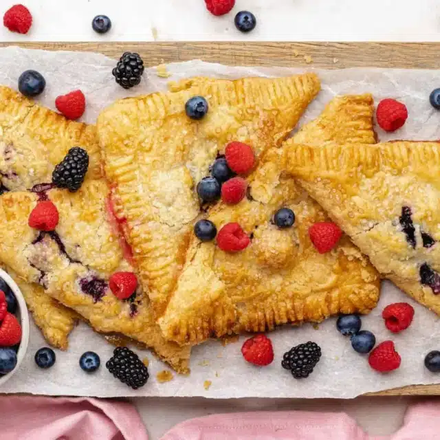 Cooked desserts on a baking sheet with berries around