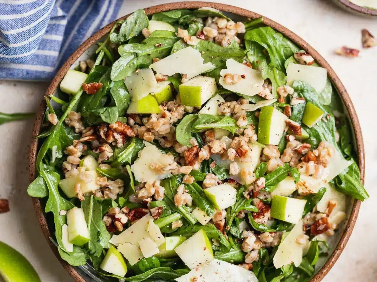 Served meal with greens, apples, farro and dressing 