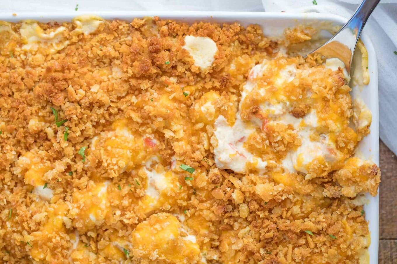 Easy Chicken Casserole is creamy and savory with chicken, onion, and bell peppers in a seasoned sauce with crackers and cheese, a perfect weeknight dinner in 45 minutes! Metal spoon serving casserole