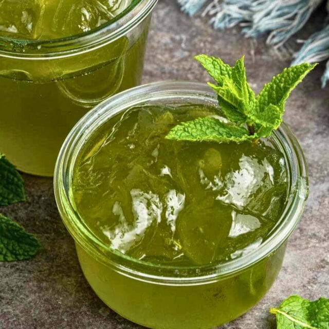Prepared green jelly in ramekin with mint sprig.