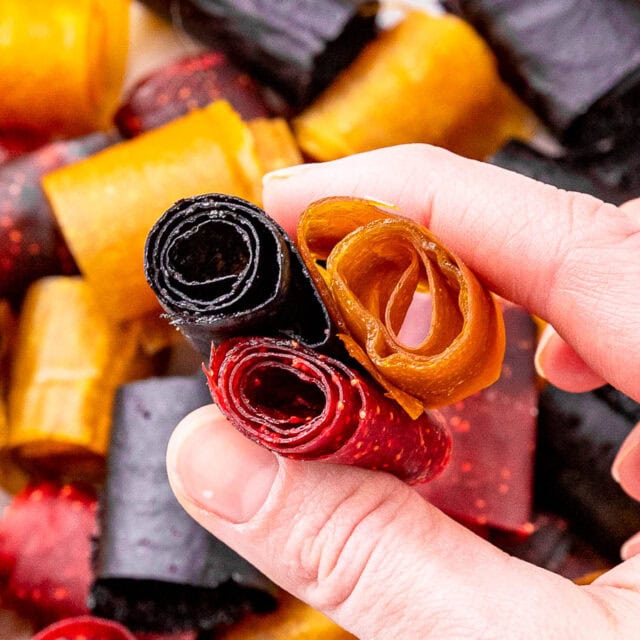 Hand holding different flavors of homemade fruit roll-ups 4x3