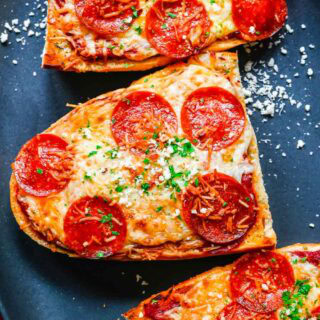 Slices of pepperoni pizza on dinner plate.