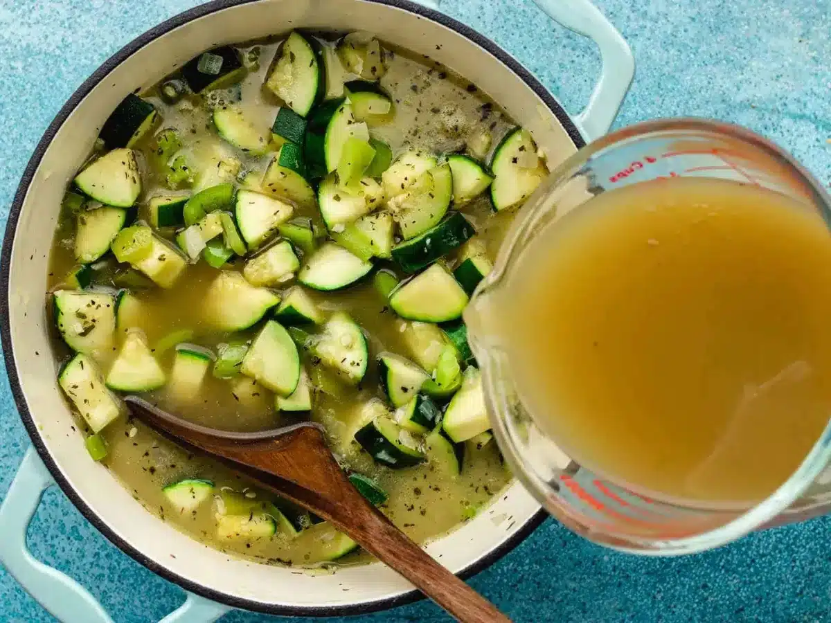 adding broth to soup