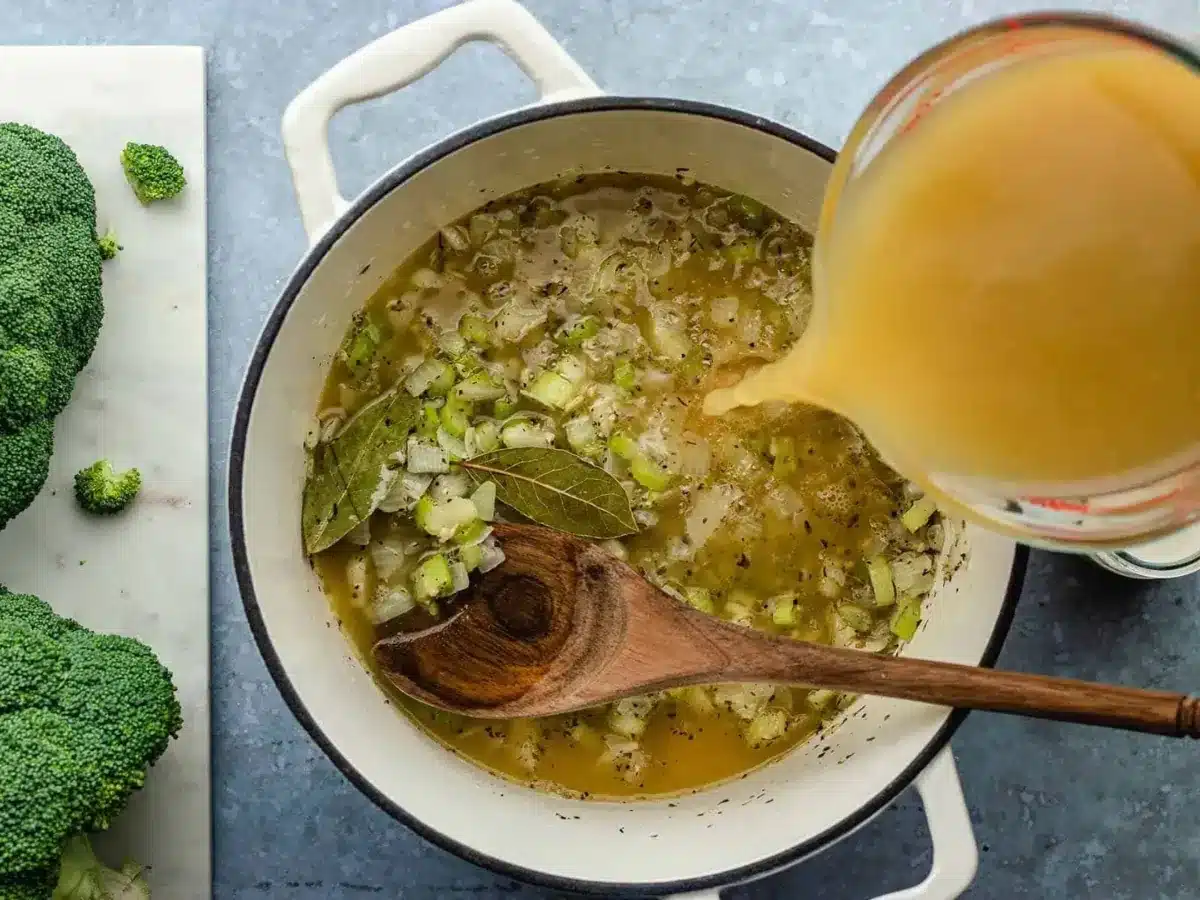 adding broth to the soup 
