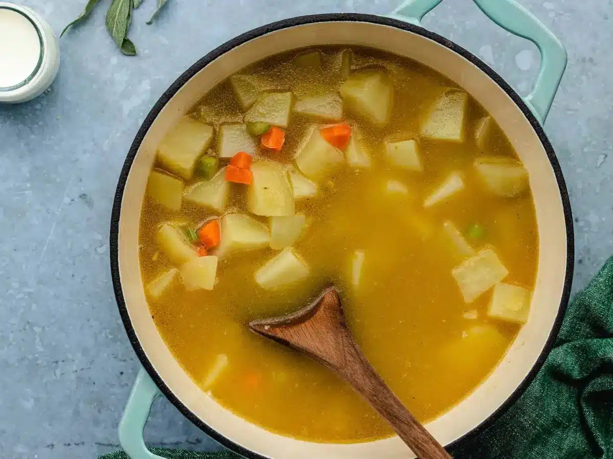adding potatoes and broth to the soup 