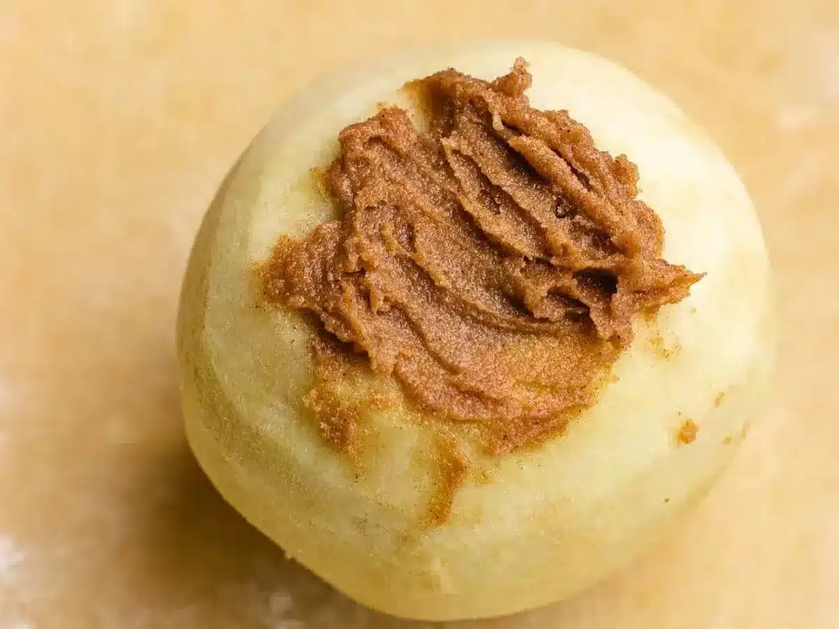 preparing apple with butter mixture on pastry 