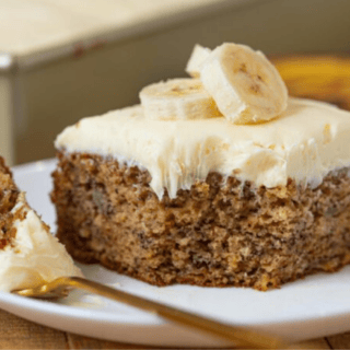 Cake topped with bananas and fork with bite