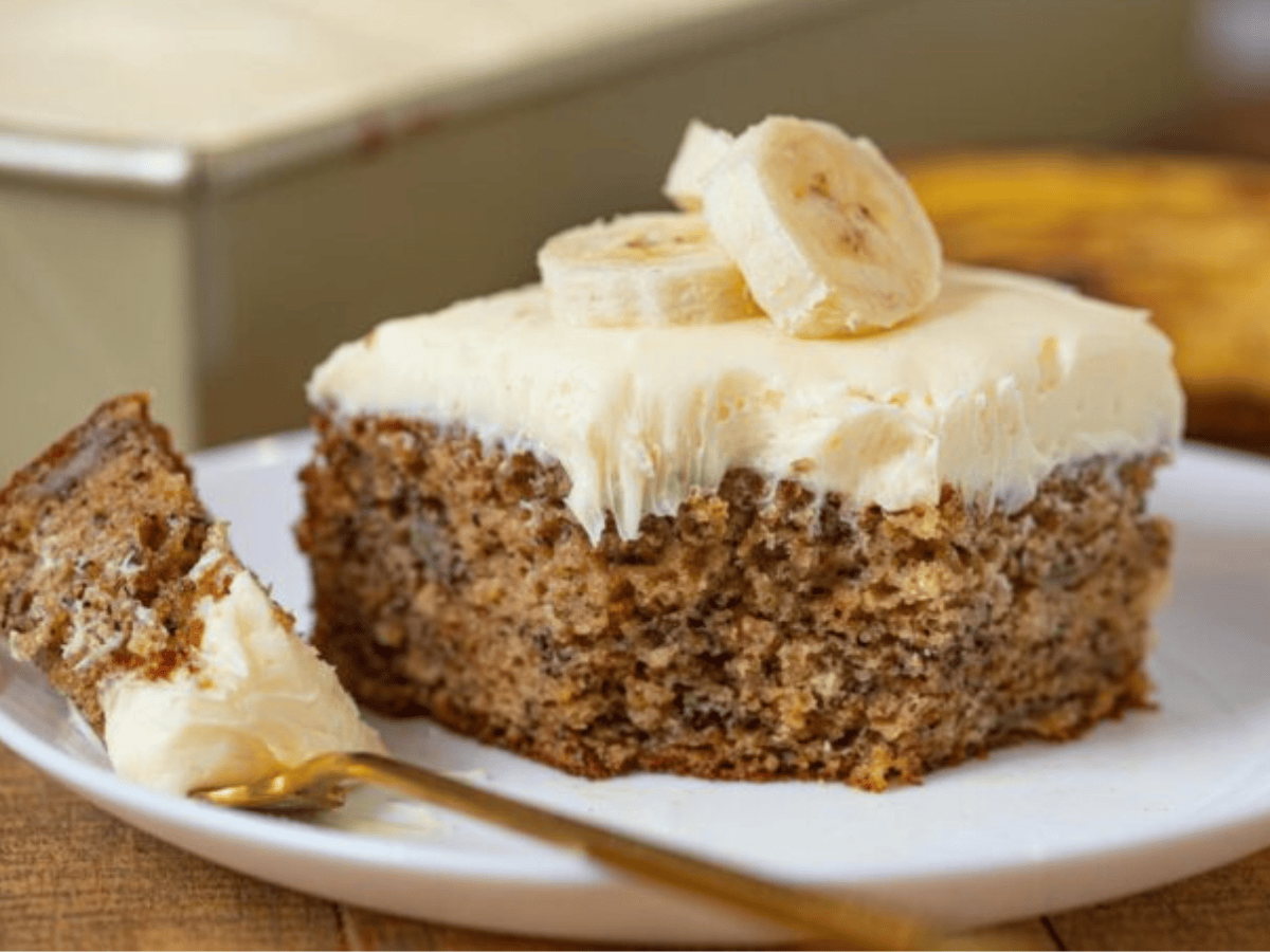 Cake topped with bananas and fork with bite