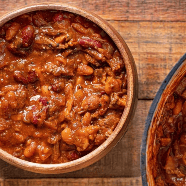Beans served in bowl with pot on side