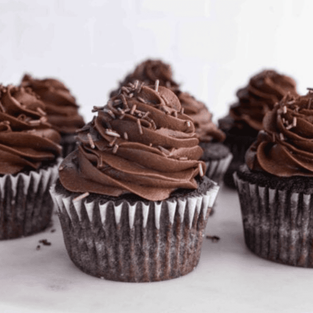 Cupcakes topped with frosting on cake stand