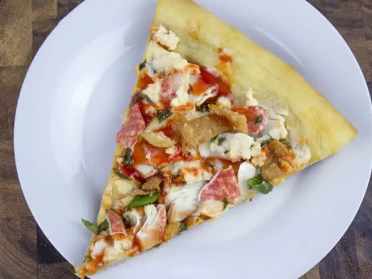 single slice of pizza on a white plate