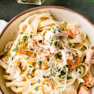 Creamy pasta and seafood dish in a bowl with a fork