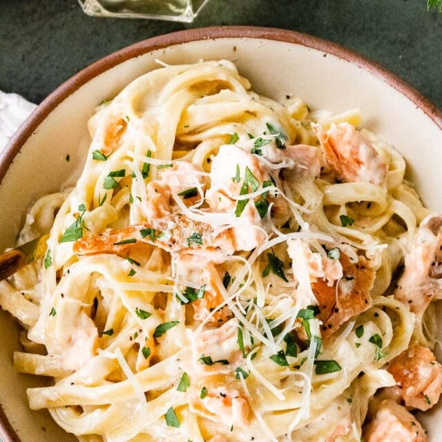 Creamy pasta and seafood dish in a bowl with a fork