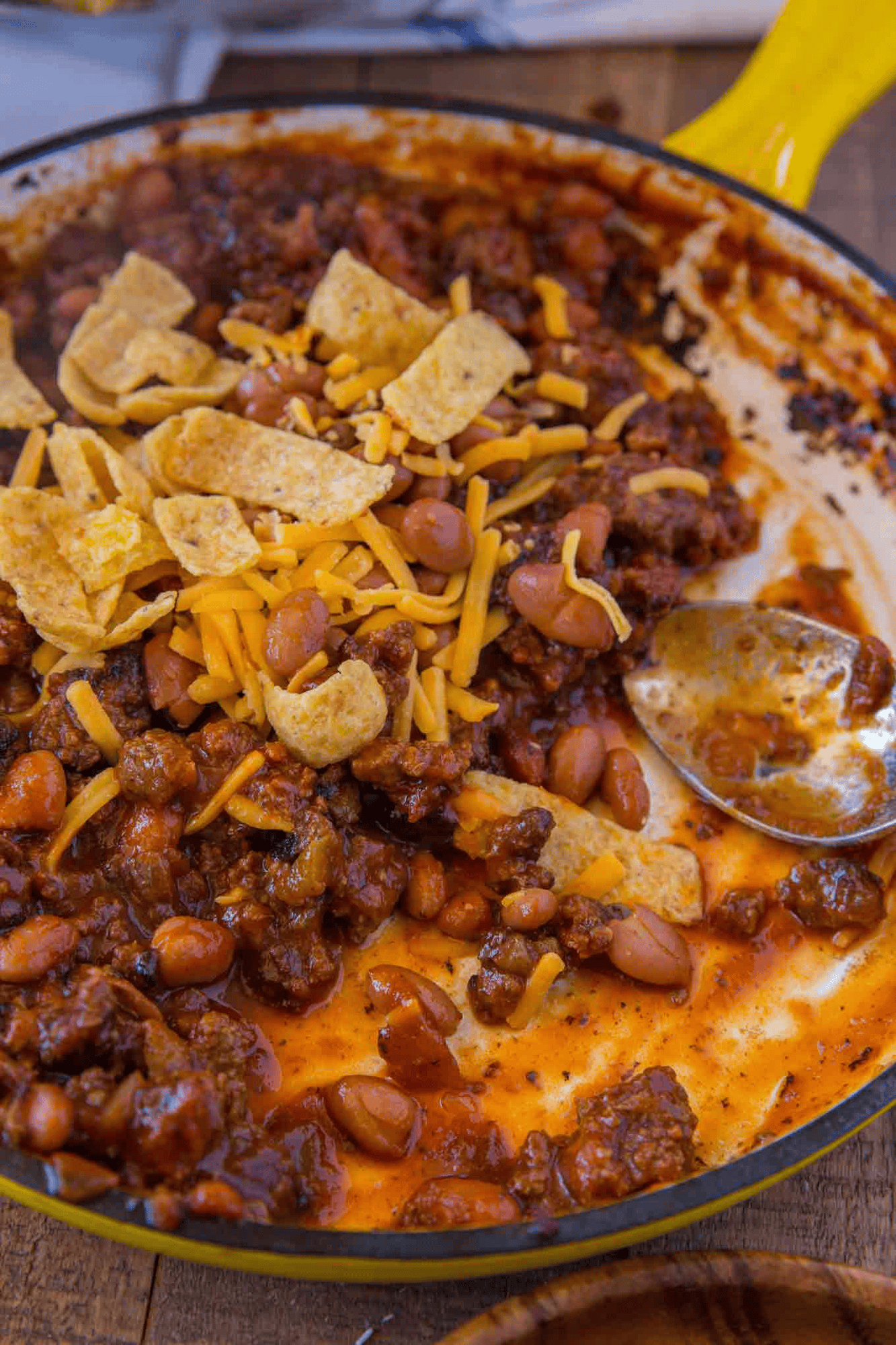 Meat and bean sauce topped with chips and cheddar cheese