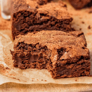 2 brownies on parchment with bite taken