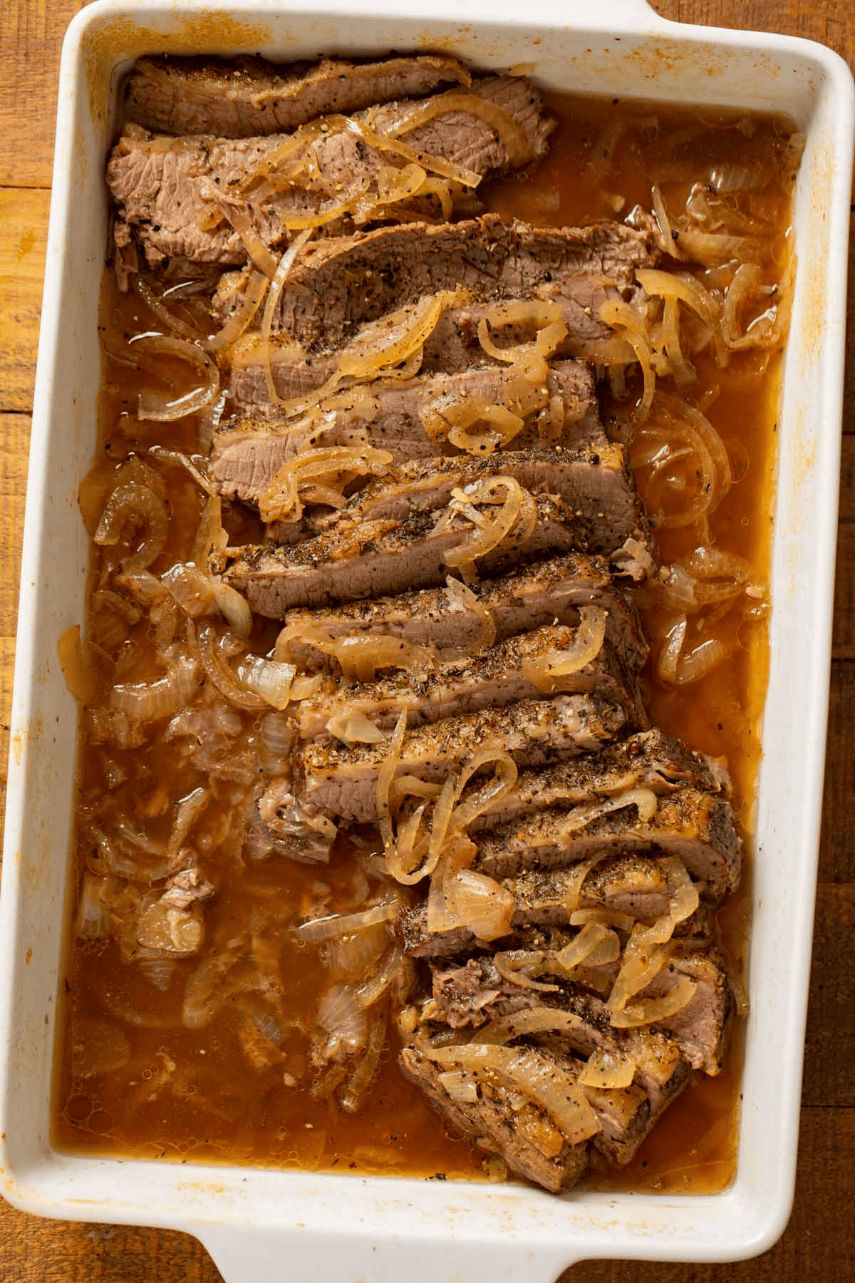 Sliced beef brisket topped with cooked onions