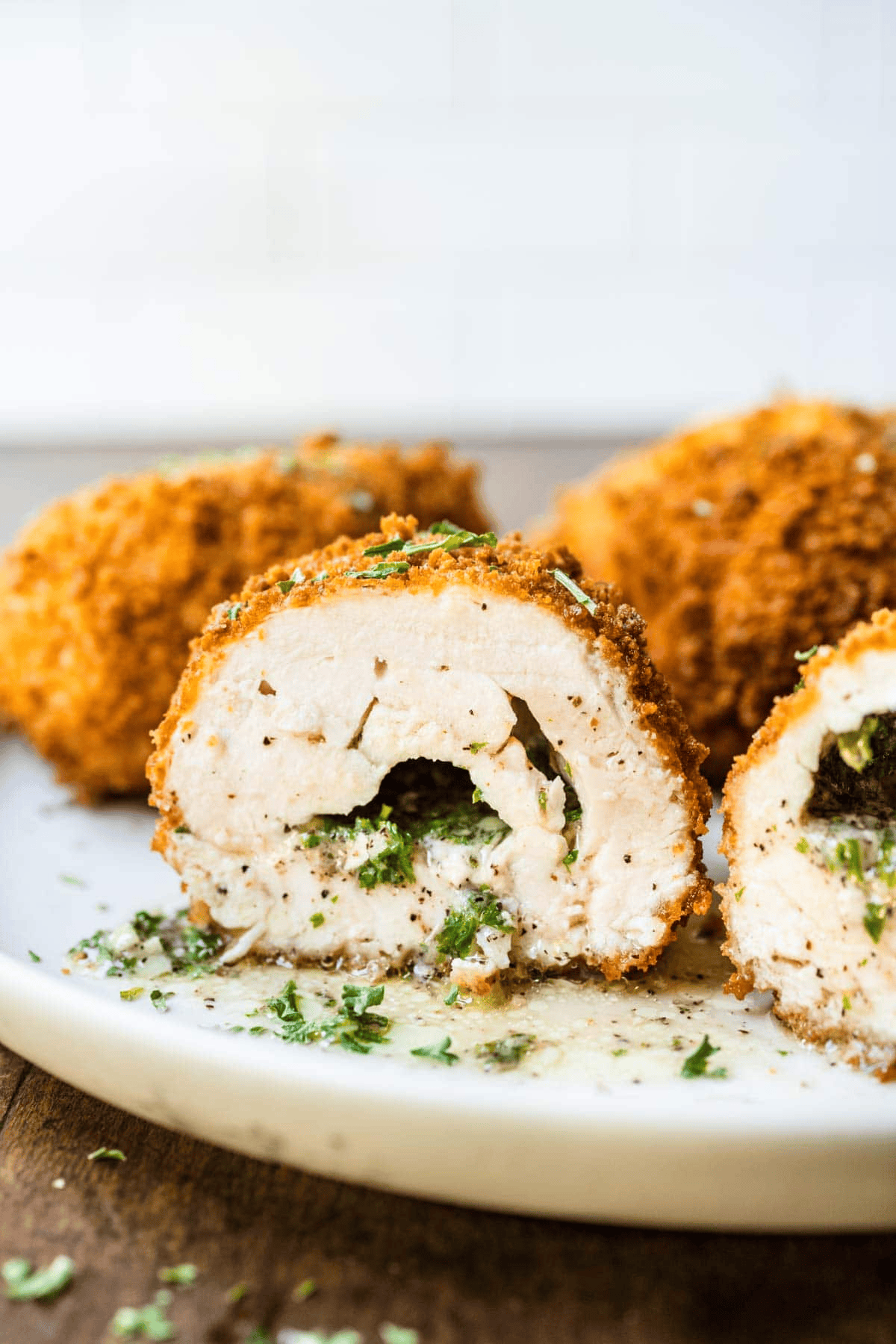 breaded chicken pieces with one sliced in half to show butter filling