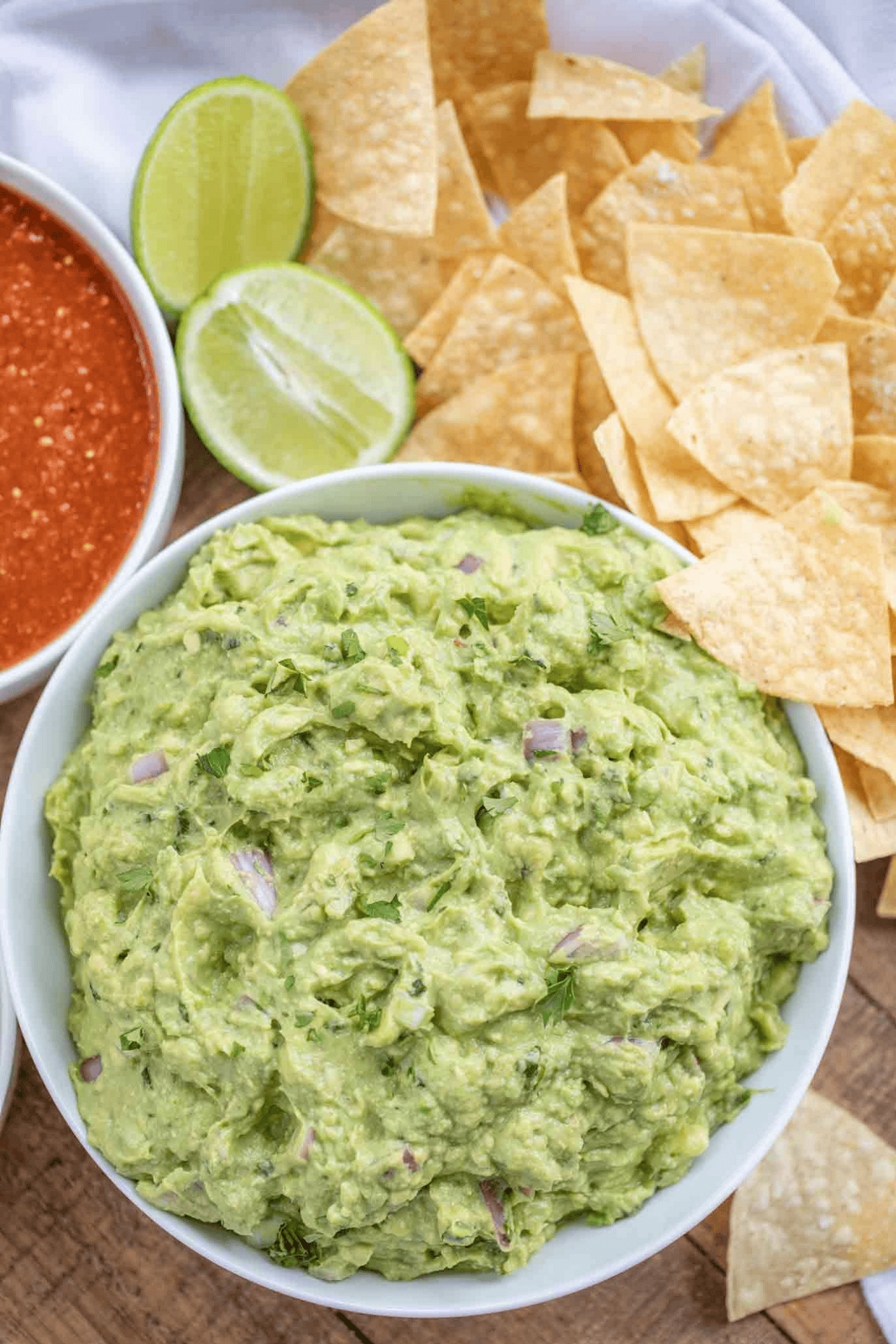 Bowl of Guacamole with chips and a bowl of salsa on the side