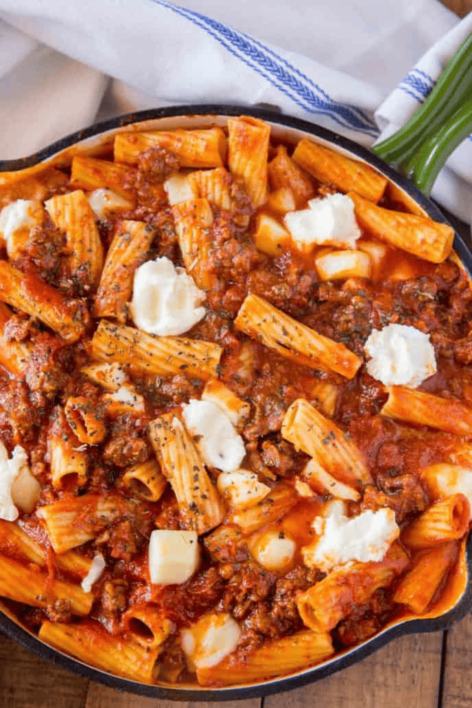 Pasta, cheese pieces, and sauce in a skillet