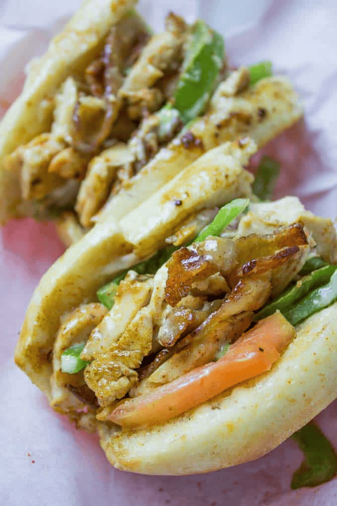 Two hoagie sandwiches with filling showing