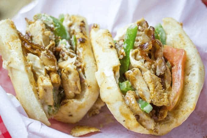 Two sub sandwiches on white paper