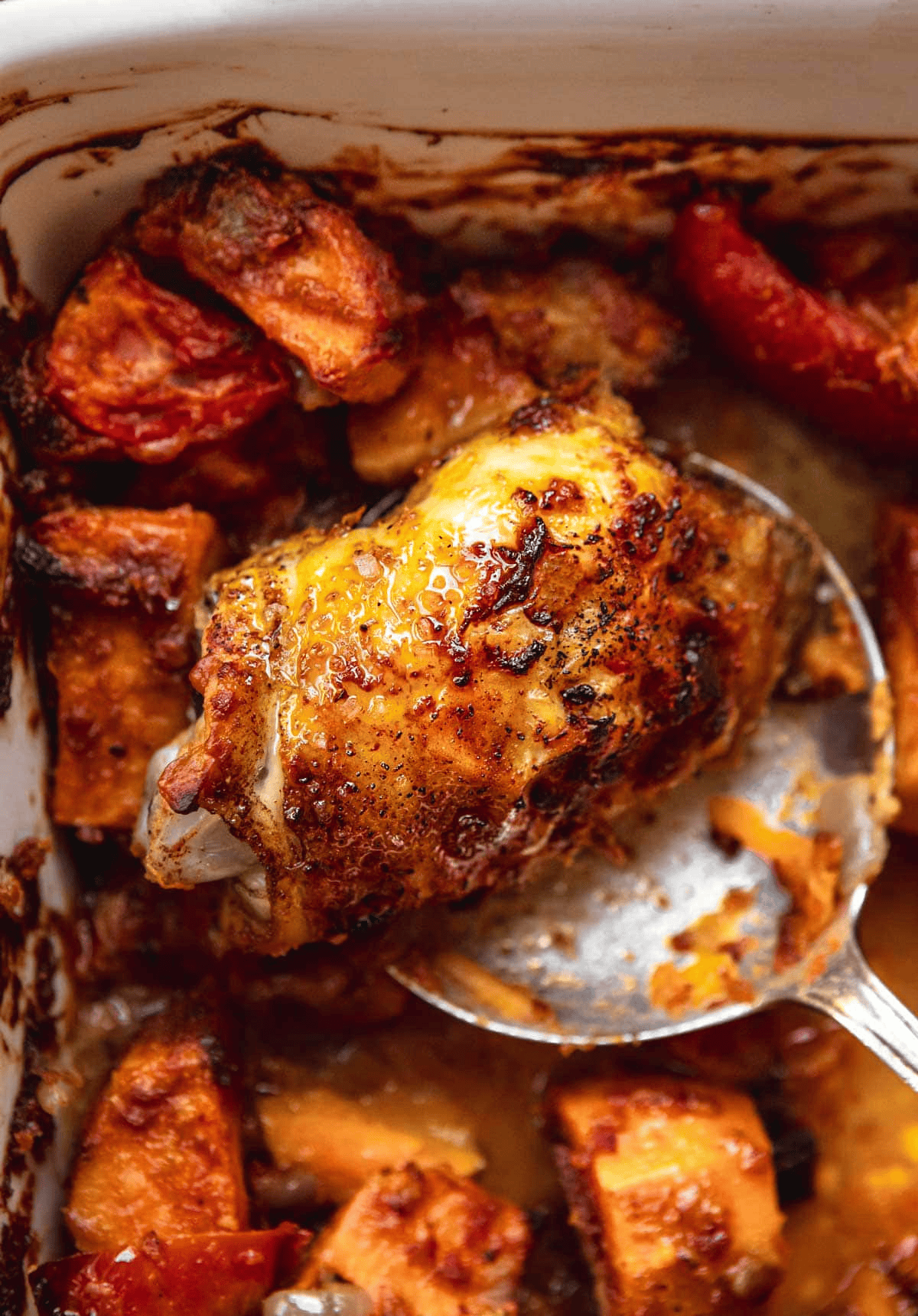 Spoon scooping chicken thigh