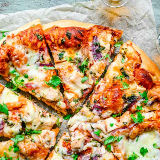 Slices of triangle shaped flat bread topped with a red sauce, cheese and vegetables