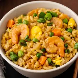 Bowl of rice with veggies and shellfish.