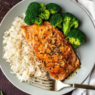 Dinner plate with salmon, rice and broccoli.