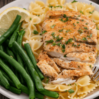Cooked fish dish on a bed of pasta with green beans