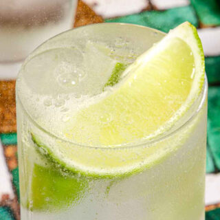 Tall cocktail with lime garnish.