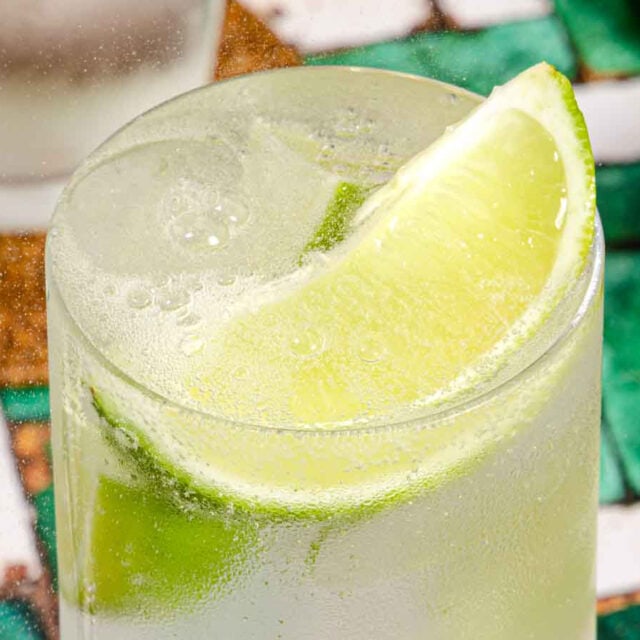 Tall cocktail with lime garnish.