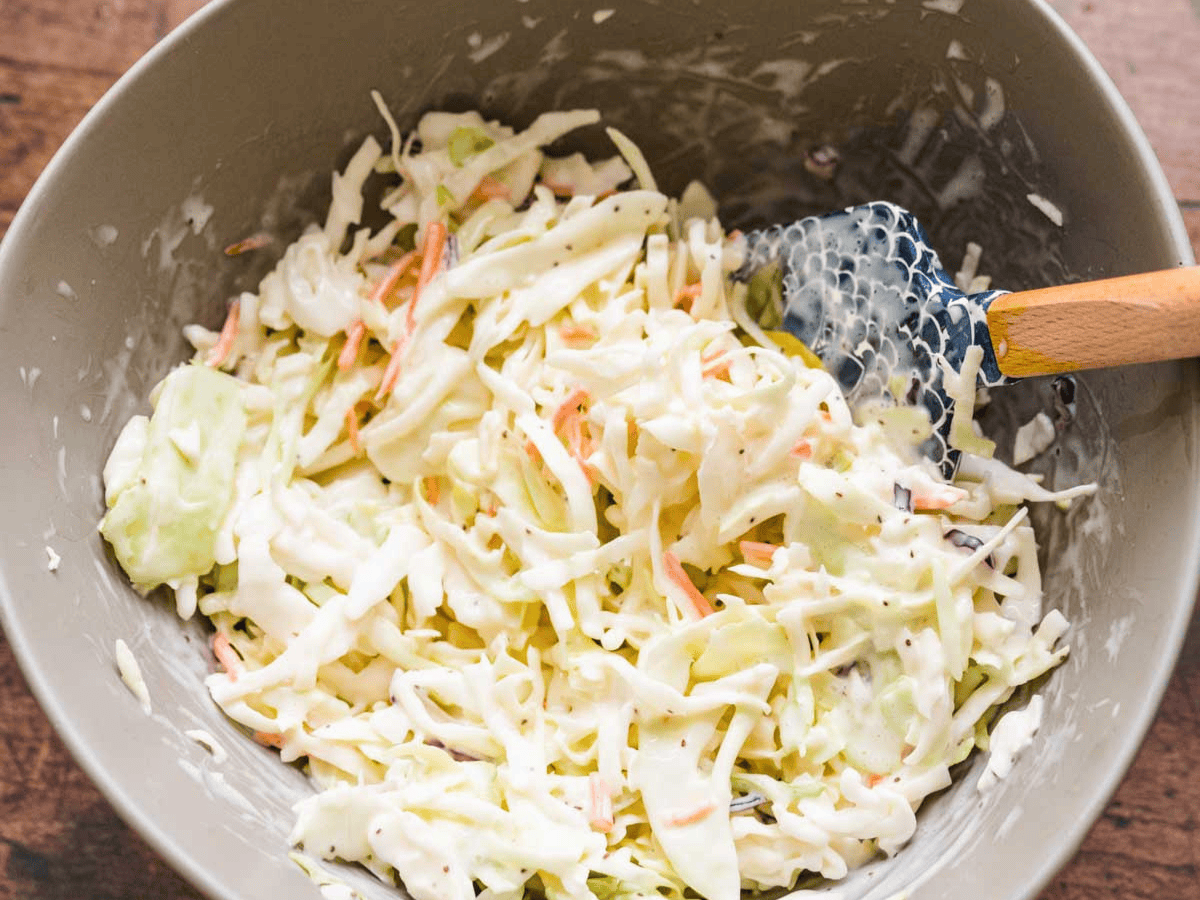 Coleslaw in bowl with spatula.