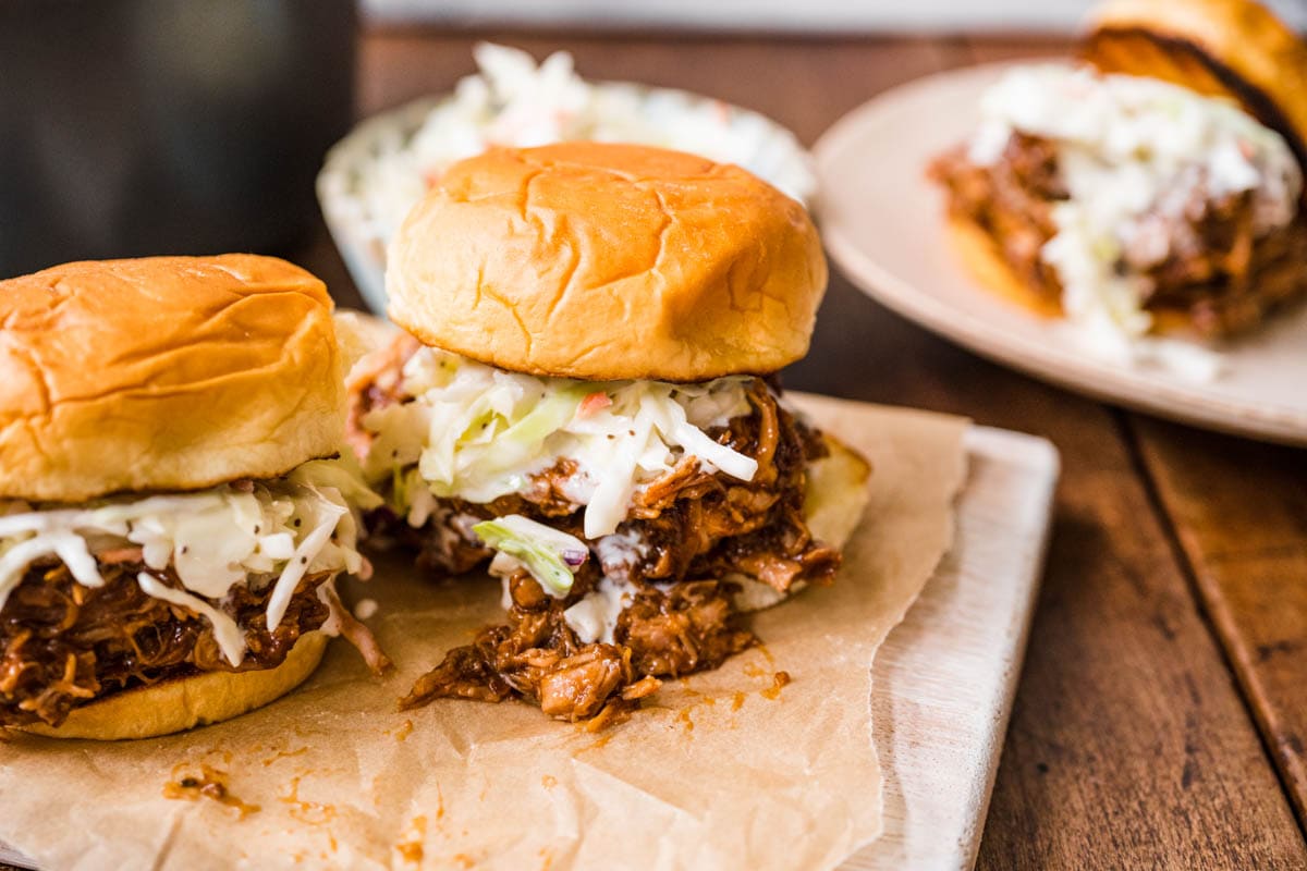 Shredded meat sandwich with coleslaw on bun.
