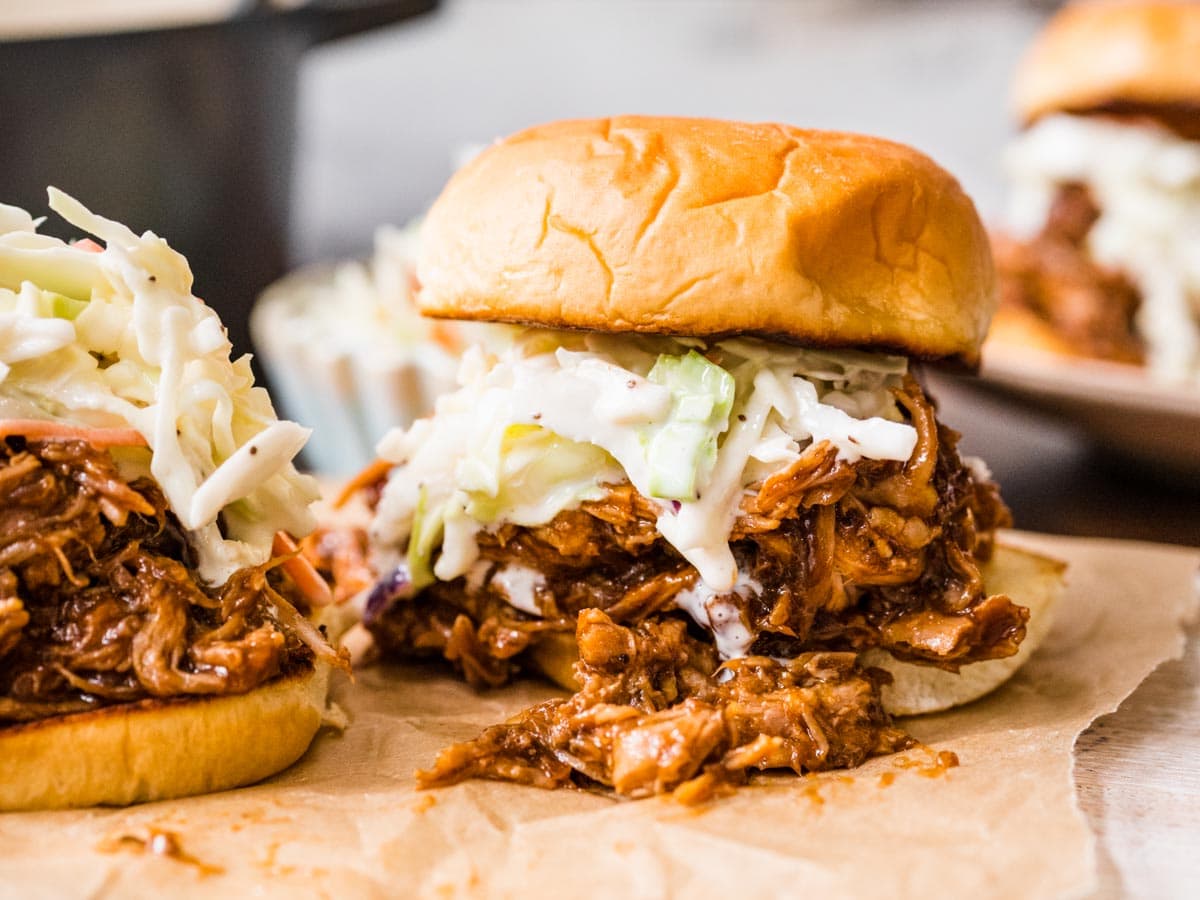 Shredded meat sandwich with coleslaw on bun.