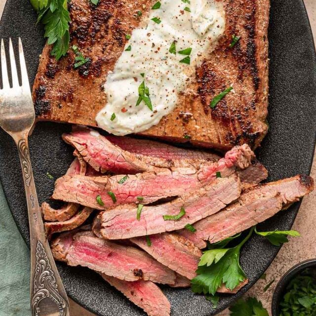 Dinner plate with beef flank and horseradish sauce.