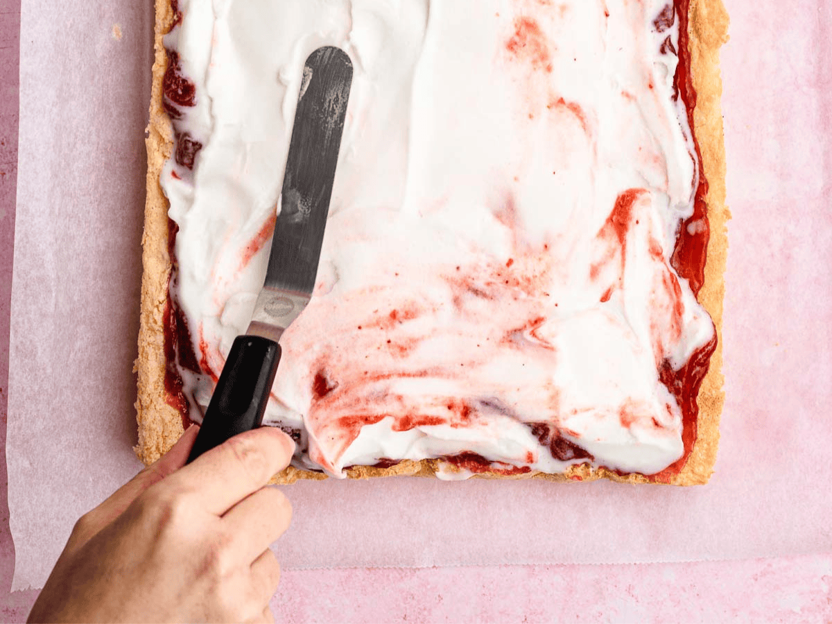 Ice cream being spread on pound cake.