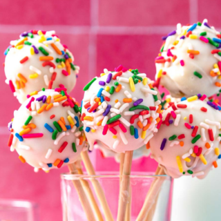 A handful of small frosted cake balls in glass.